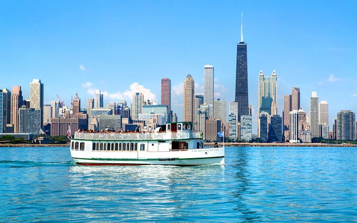 Chicago River cruise boat with city skyline in the background.