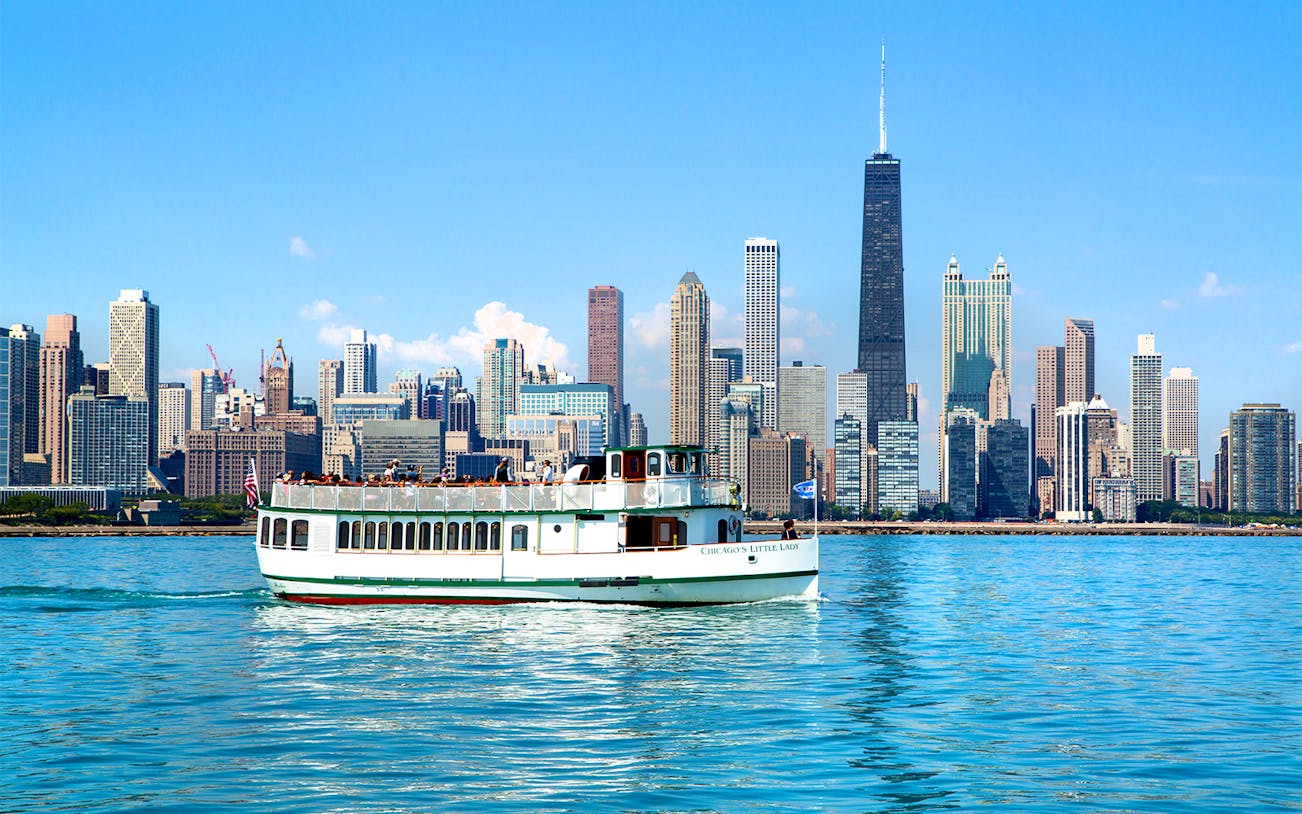 Chicago River cruise boat with city skyline in the background.