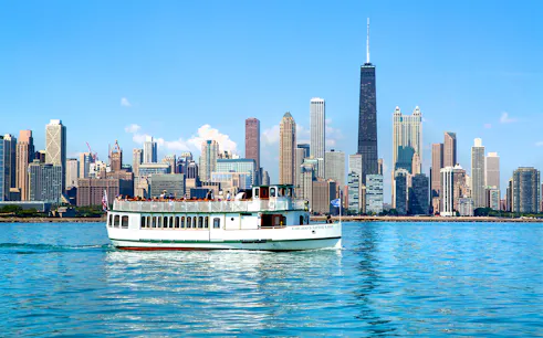 Chicago River cruise boat with city skyline in the background.