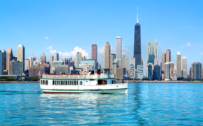 Chicago River cruise boat with city skyline in the background.