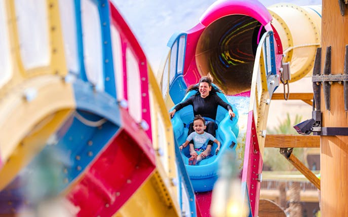 Mother and son on water slide at Aquarabia Qiddiya.