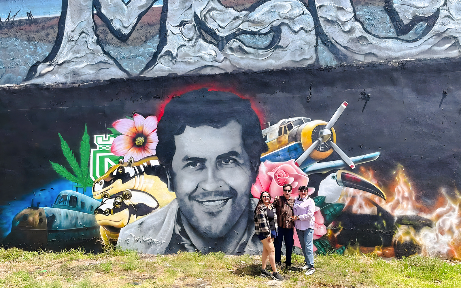 Street art mural at Wynwood Walls, Miami, featuring a portrait surrounded by vibrant elements and visitors.