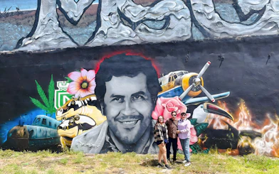 Street art mural at Wynwood Walls, Miami, featuring a portrait surrounded by vibrant elements and visitors.