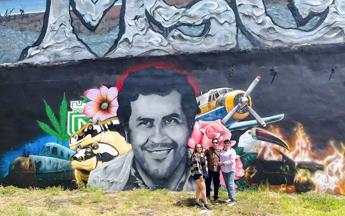 Street art mural at Wynwood Walls, Miami, featuring a portrait surrounded by vibrant elements and visitors.