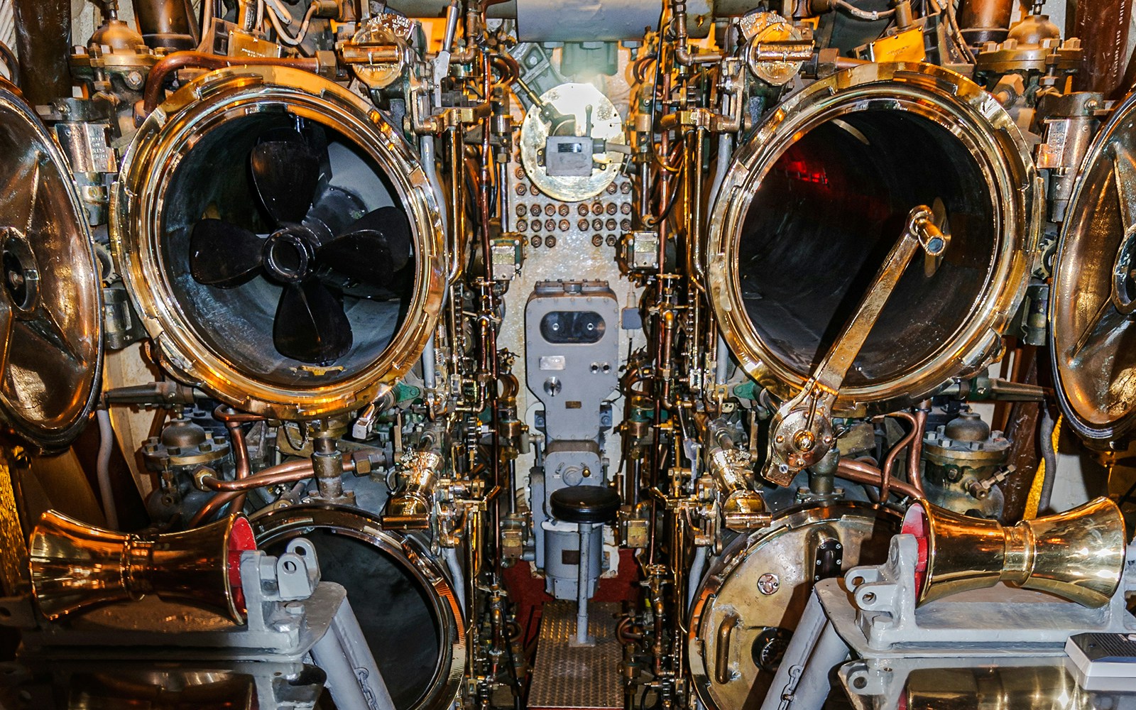 USS Bowfin submarine torpedo room with torpedo tubes and control panel.