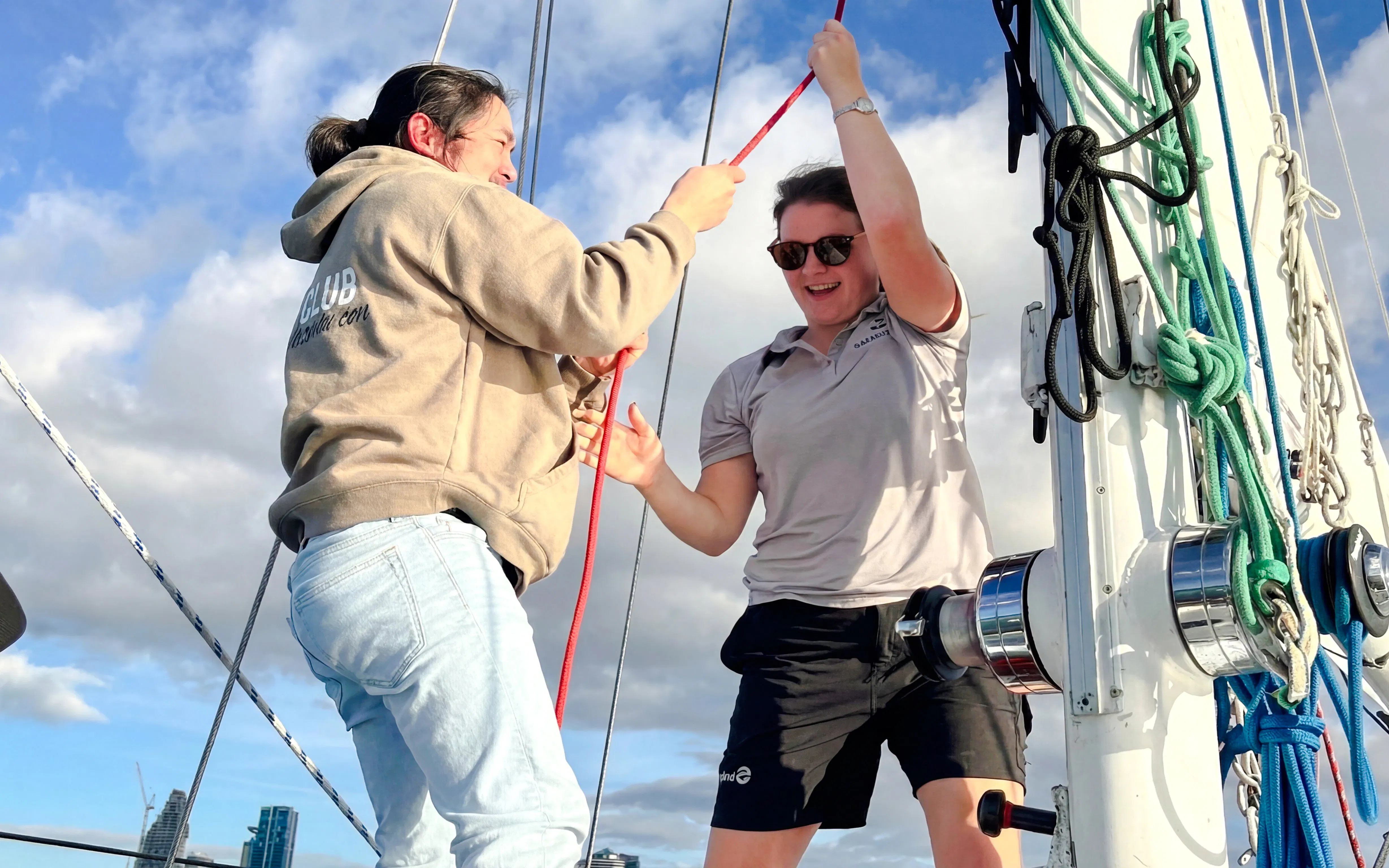 Sailors adjusting ropes on a yacht during Auckland Waitematā Harbour sailing cruise.
