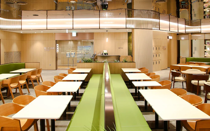 Wooden chairs and tables arranged at Plaza Premium Lounge, South Korea.