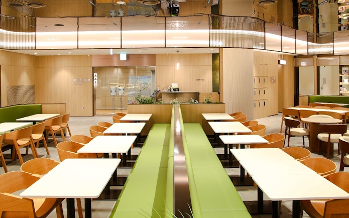 Wooden chairs and tables arranged at Plaza Premium Lounge, South Korea.