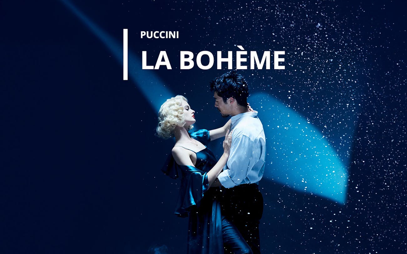 Couple dancing under spotlight in La Bohème performance.