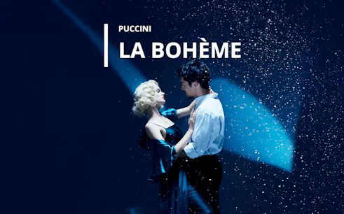 Couple dancing under spotlight in La Bohème performance.