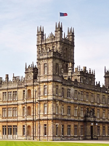 Highclere Castle, iconic setting for Downton Abbey, with a flag atop its tower.
