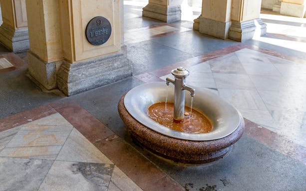 Karlovy Vary thermal spring fountain with mineral water flowing, Czech Republic.