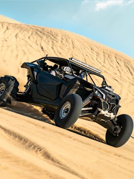 Buggy driving on sand dunes in Dubai desert.