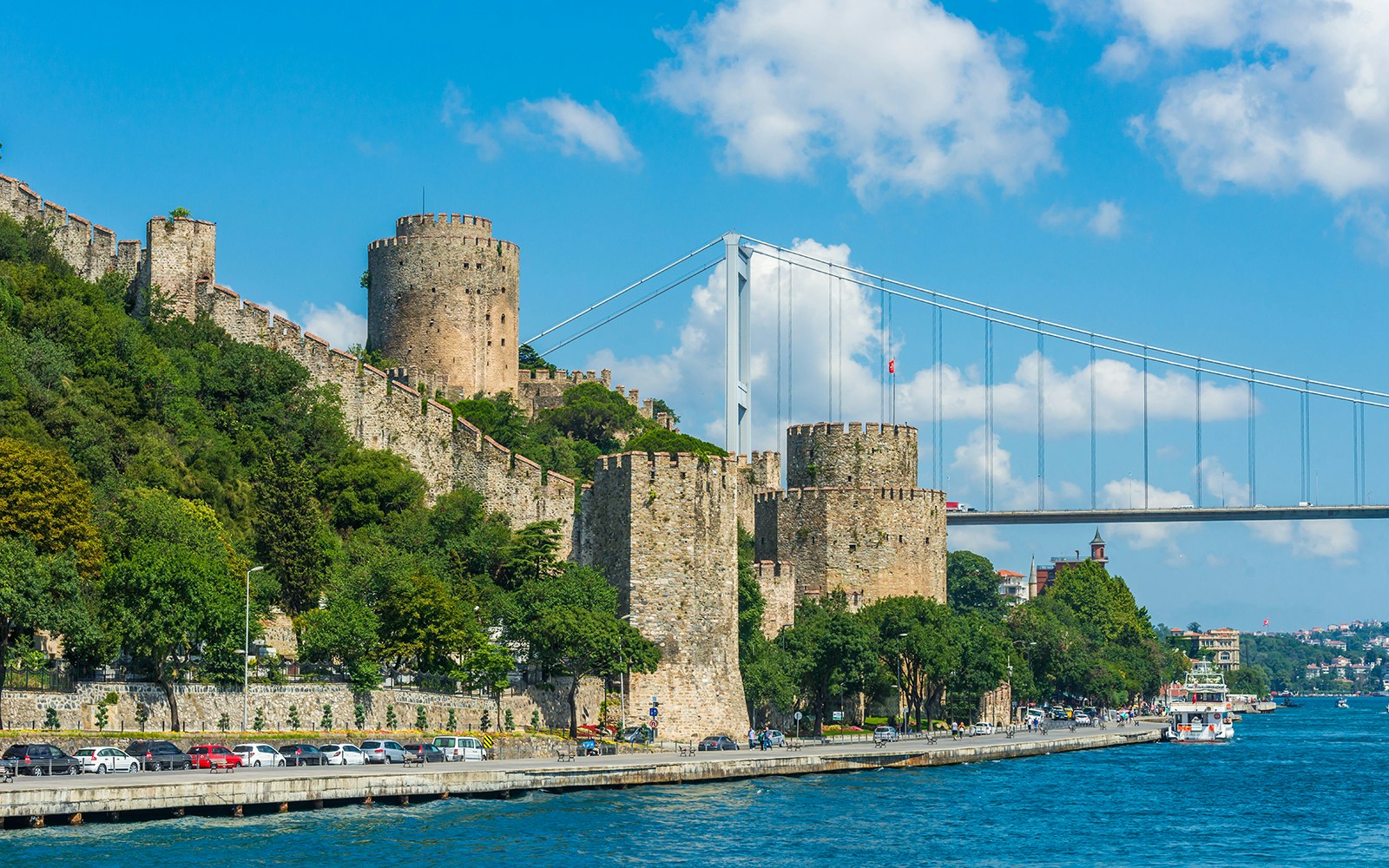 Private yacht cruising past Rumeli Fortress on the Bosphorus in Istanbul.