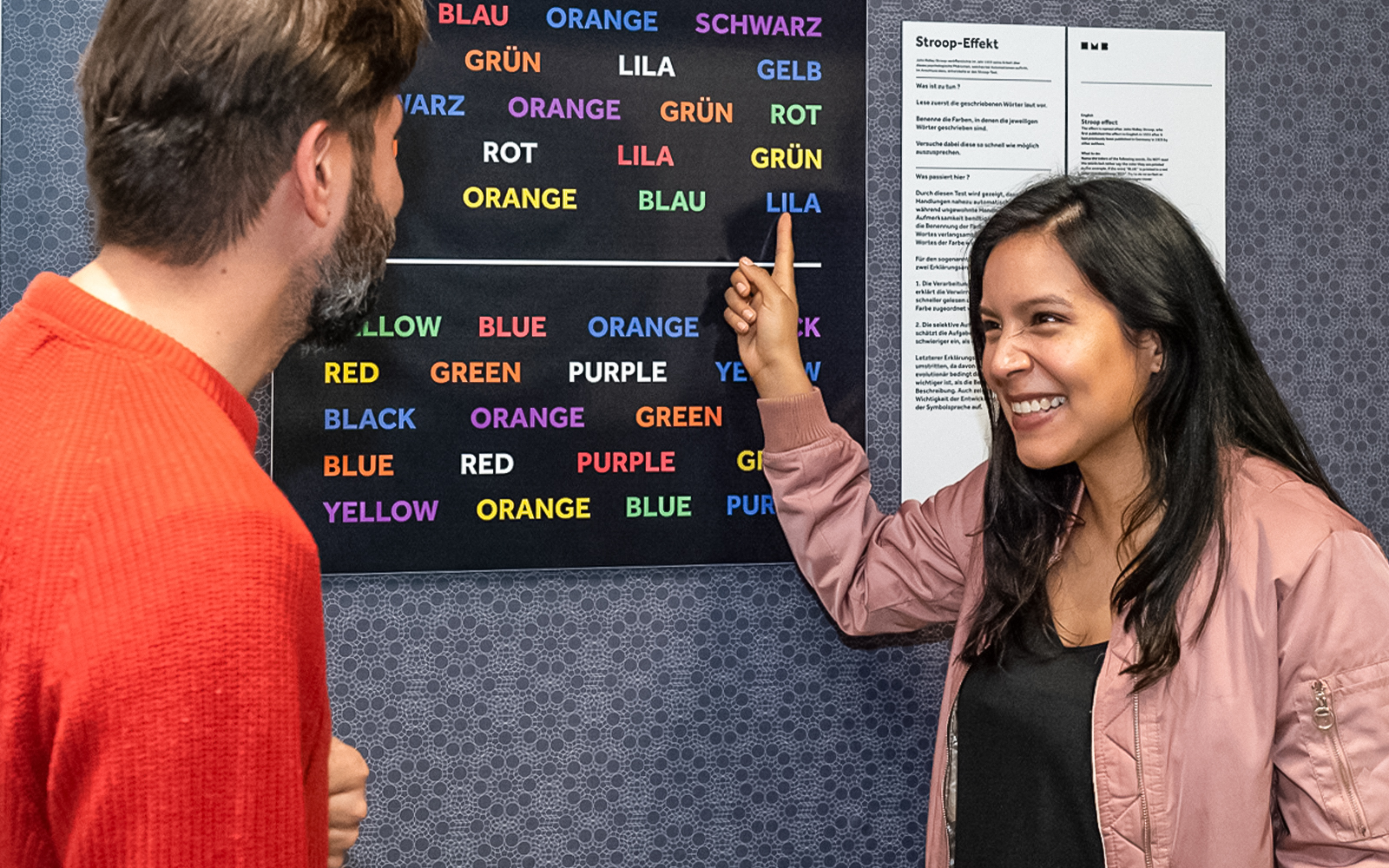 Eine Frau und ein Mann stehen im Illuseum Berlin vor einer Knobelaufgabe