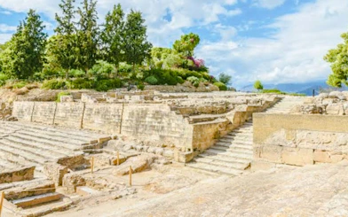 Phaistos Palace ruins with stone steps and greenery, Minoan site, Santorini.