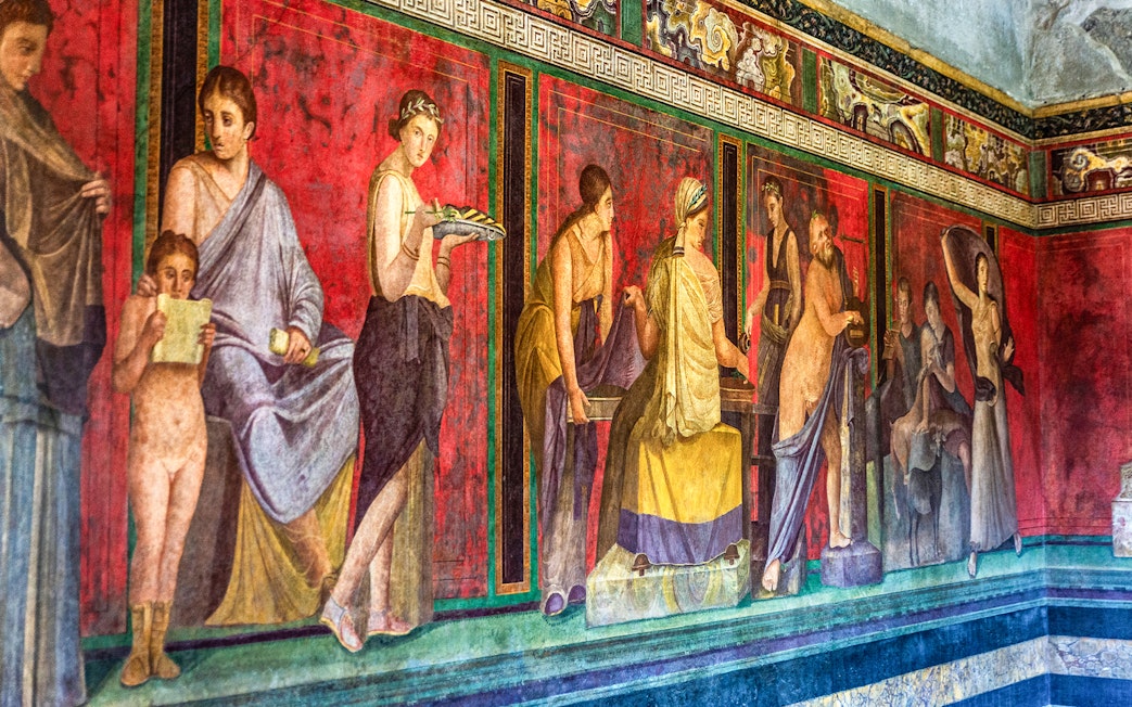 Ancient fresco in Pompeii depicting figures in vibrant colors, showcasing Roman art in Naples, Italy.