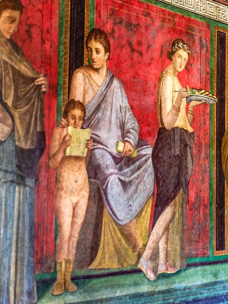 Ancient fresco in Pompeii depicting figures in vibrant colors, showcasing Roman art in Naples, Italy.