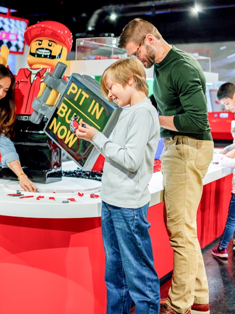 Guests building Lego cars at the Ferrari garage zone, Legoland, New York.