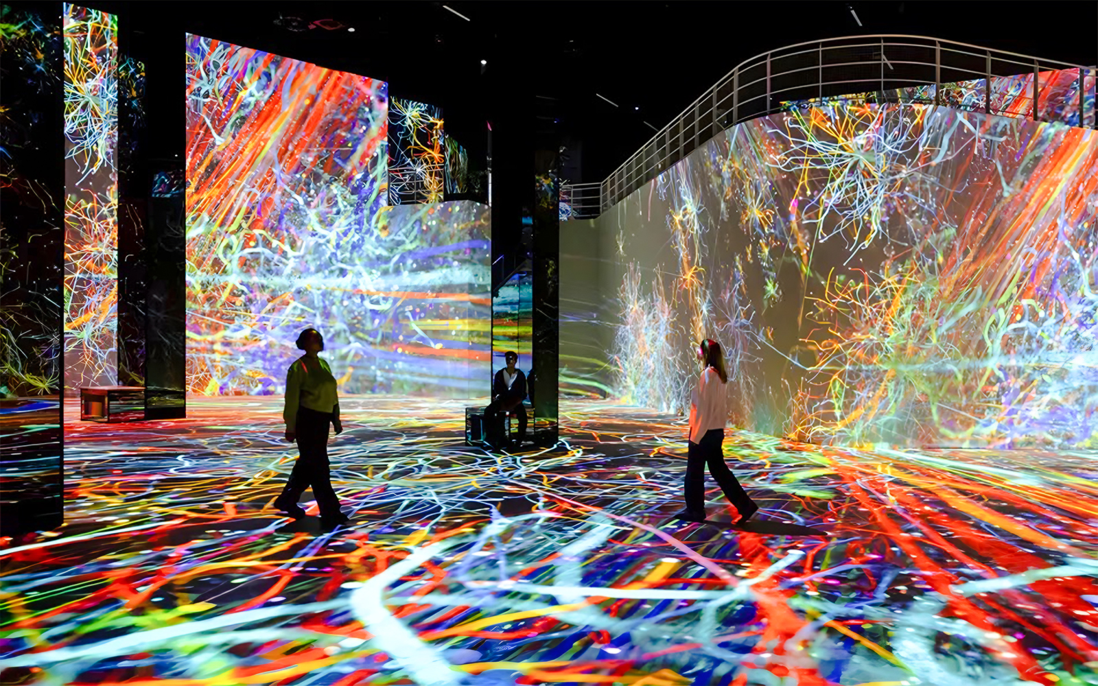 Visitors exploring vibrant digital art at Journey Exhibit, Port des Lumières, Hamburg.