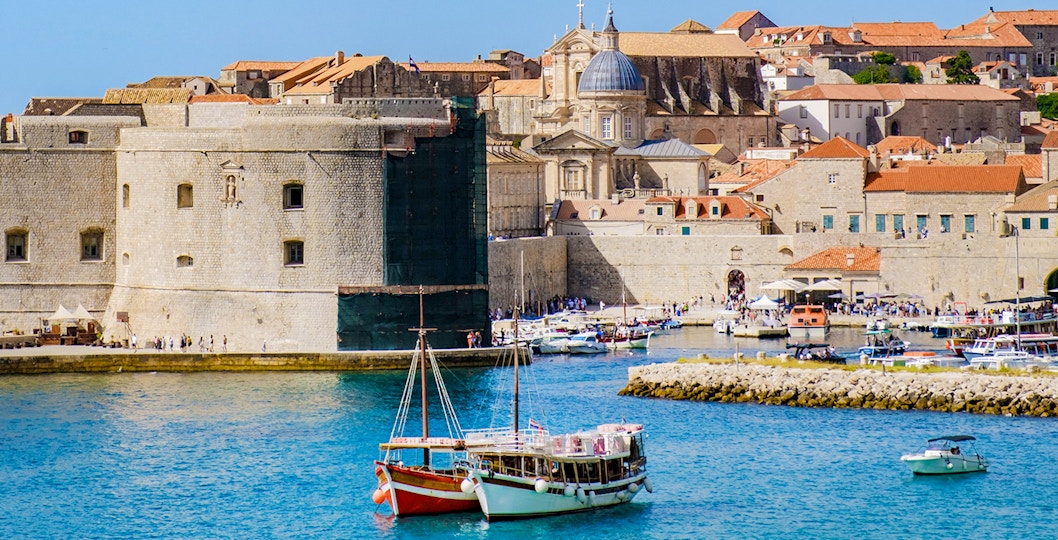 Boats anchored in front of Dubrovnik's historic old town walls, Croatia.