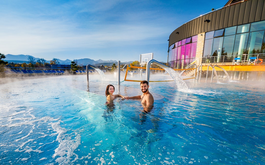 Tourists enjoying Chocholow Thermal Baths with mountain view.