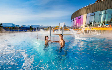 Tourists enjoying Chocholow Thermal Baths with mountain view.