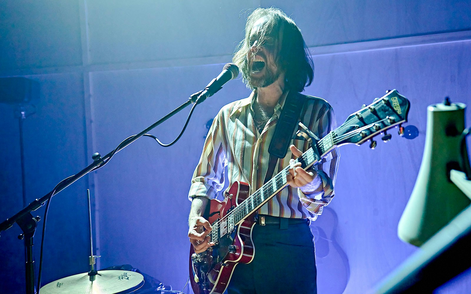Musician performing on stage with a guitar during Kenrex event.