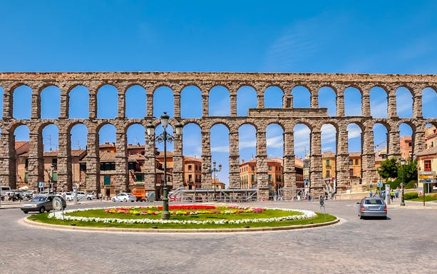 Aqueduct of Segovia with arches and cityscape in the background, Segovia, Spain.
