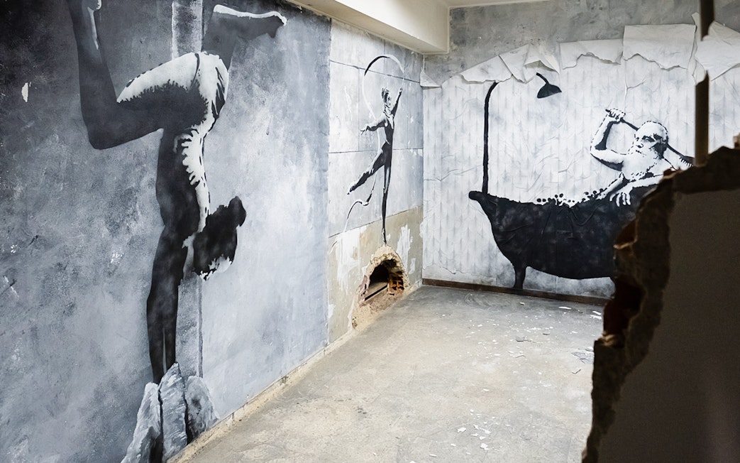 Street art murals at The Banksy Museum in Lisbon featuring acrobat and bather.