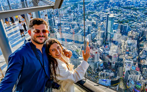 Couple enjoying city view from Shibuya Sky observation deck in Tokyo.