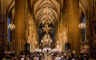 Choir performing inside St. Stephen's Cathedral, Vienna, with audience seated.