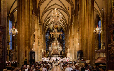 Choir performing inside St. Stephen's Cathedral, Vienna, with audience seated.