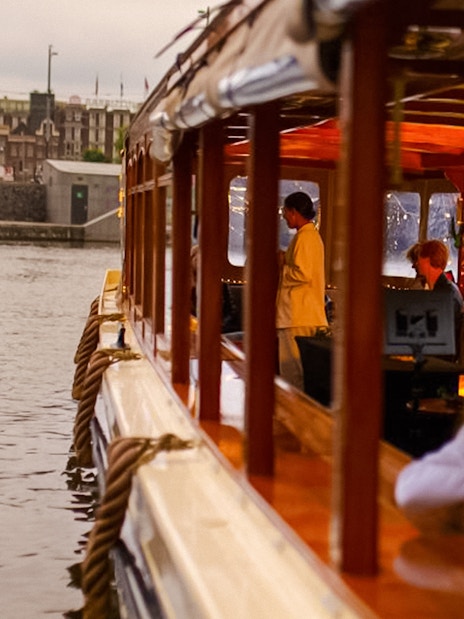 Luxury canal cruise in Amsterdam during Light Festival with passengers inside.