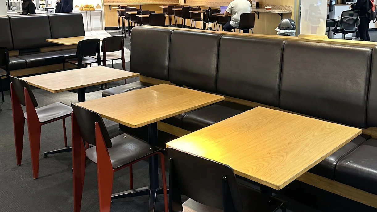 Seating area at HelloSky Lounge, JFK Terminal 4, New York, with tables and chairs.