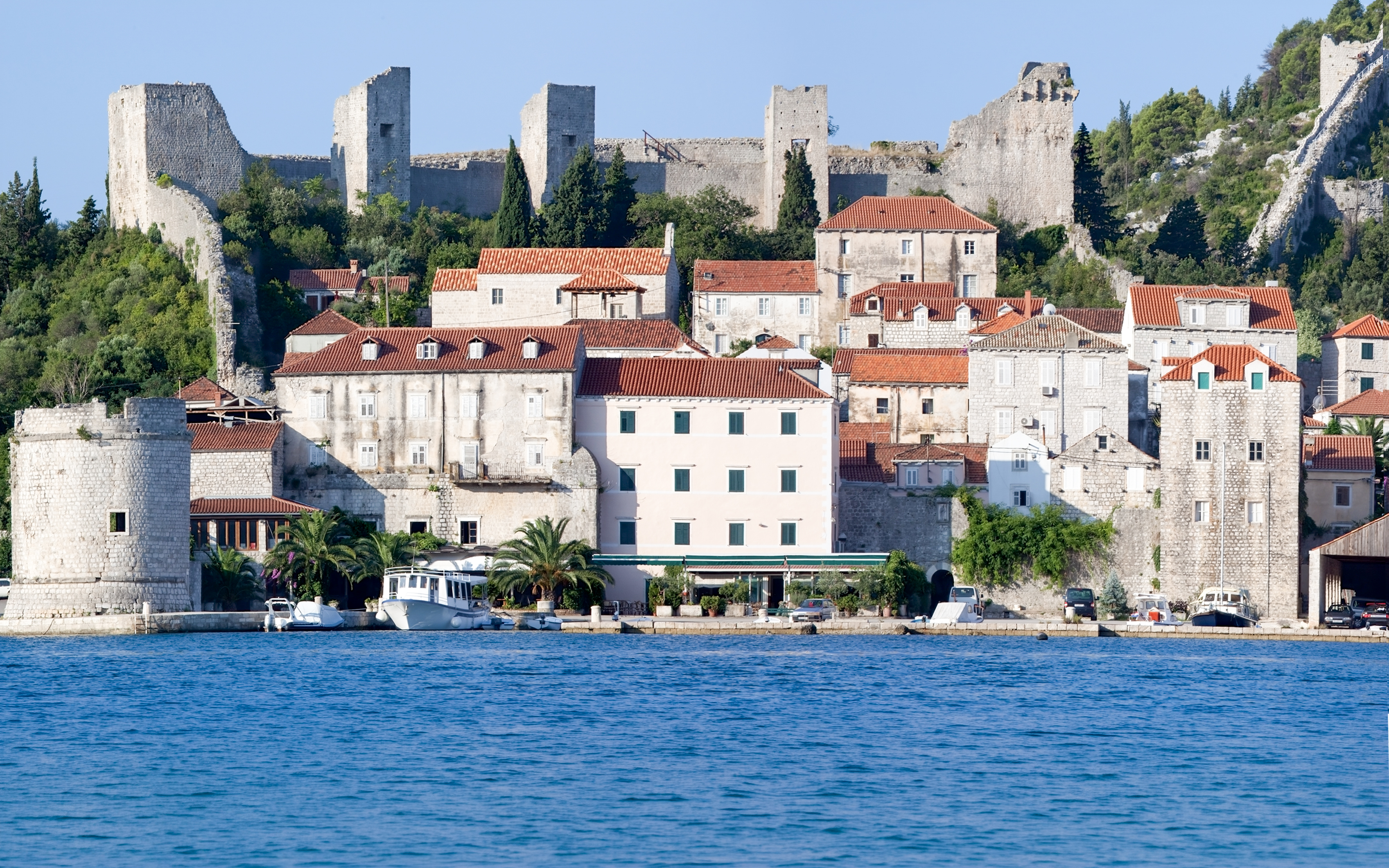 Stone walls and historic buildings in Town Ston near Dubrovnik, Croatia, viewed from the water.