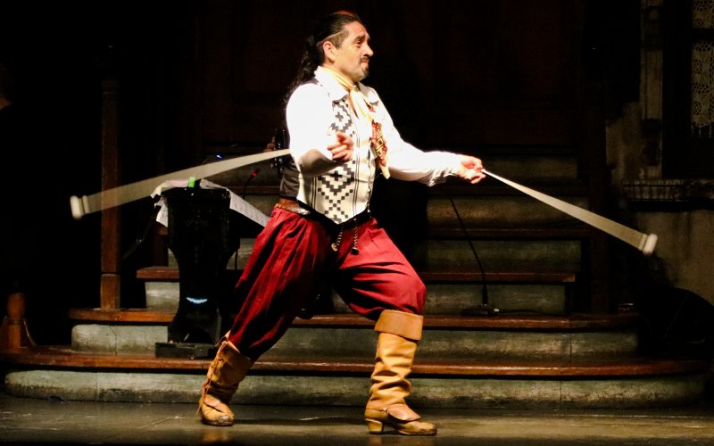 Tango artist performing with boleadoras at Aljibe Tango Show in Buenos Aires.