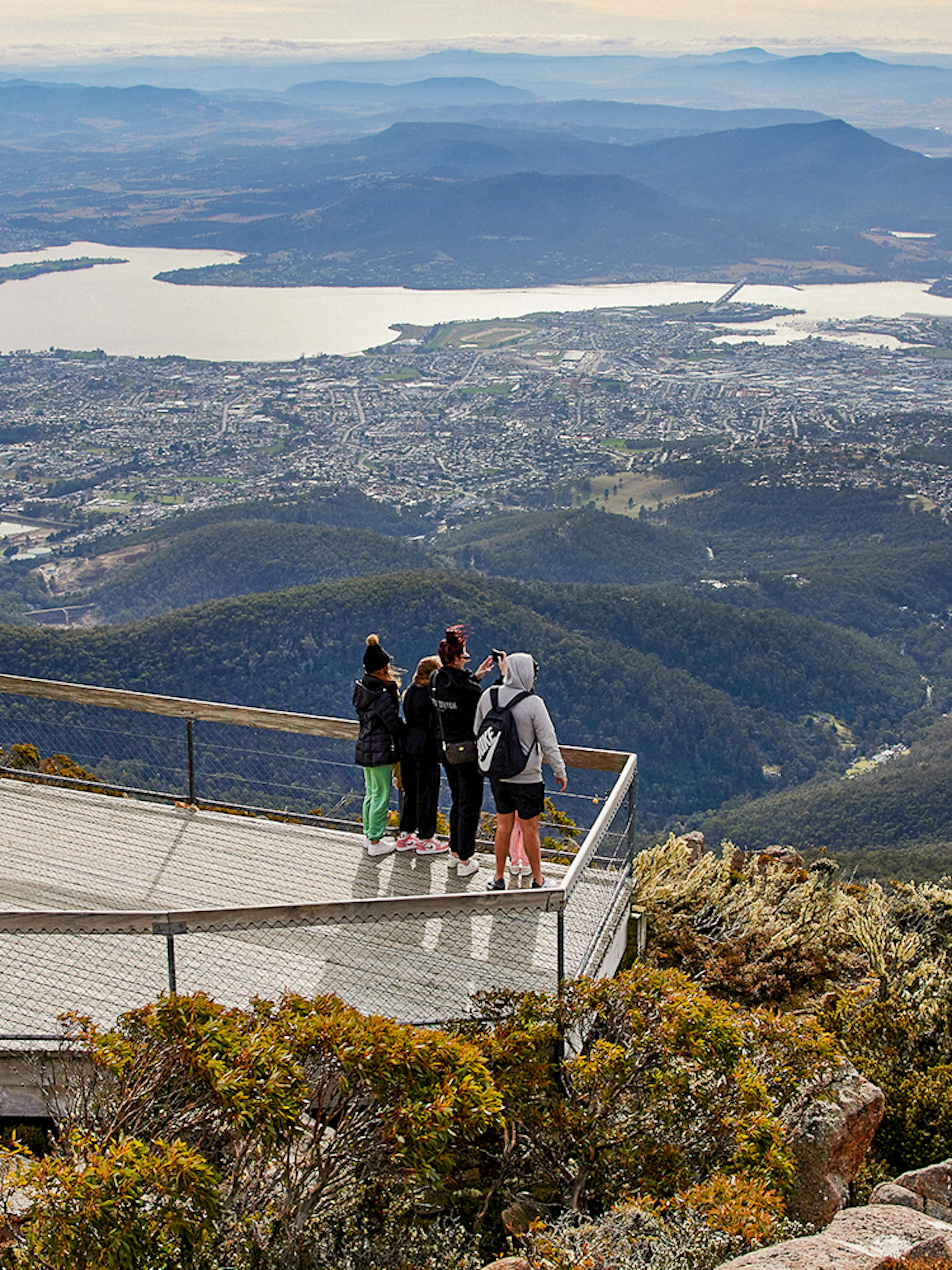 Visitors on Mt Wellington lookout with panoramic view of Hobart, Tasmania.