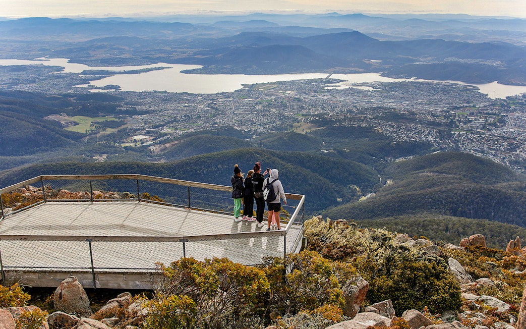 Visitors on Mt Wellington lookout with panoramic view of Hobart, Tasmania.