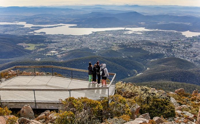 Visitors on Mt Wellington lookout with panoramic view of Hobart, Tasmania.
