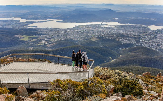 Visitors on Mt Wellington lookout with panoramic view of Hobart, Tasmania.