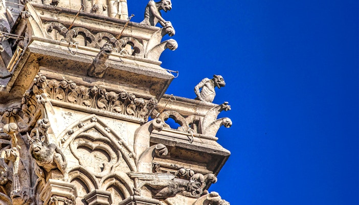 Notre-Dame Cathedral facade with tourists using audio guides in Paris.