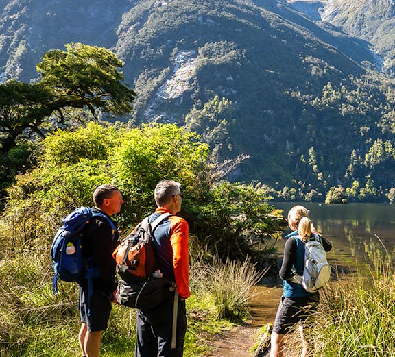 Hikers on Milford Track with mountain view in New Zealand.