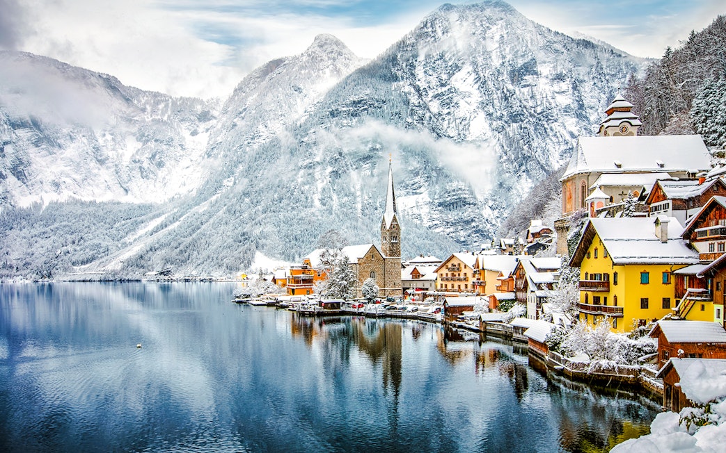 Hallstatt Church by a snowy lake in winter, Austria.