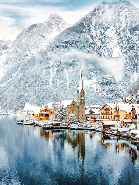 Hallstatt Church by a snowy lake in winter, Austria.
