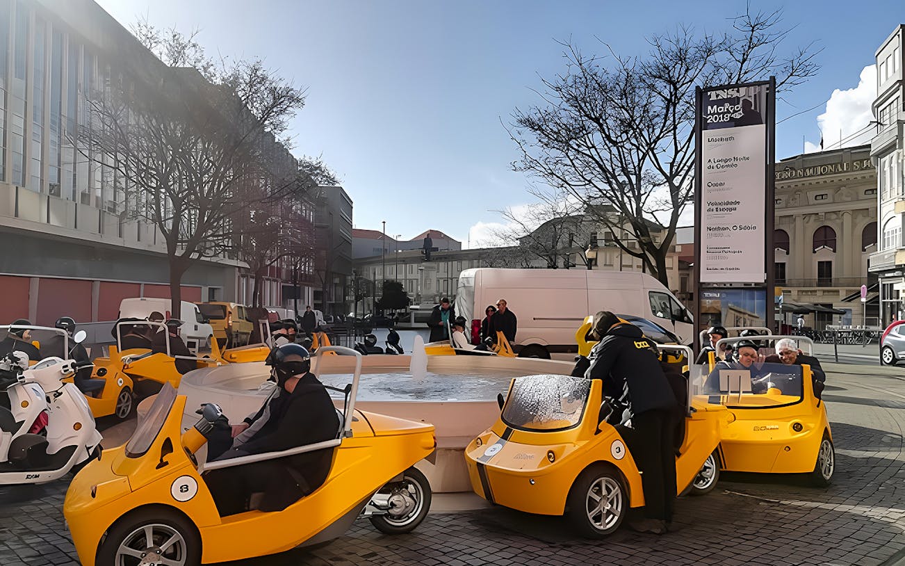 Yellow GoCars parked near a fountain in Porto during a self-guided tour.