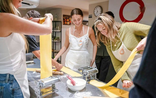 Participants making pasta in a Florence cooking class.