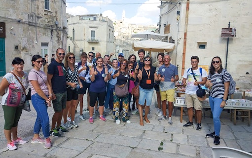 Group of tourists in Sassi of Matera during 45-min tour with guide.