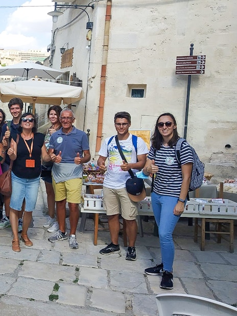 Group of tourists in Sassi of Matera during 45-min tour with guide.