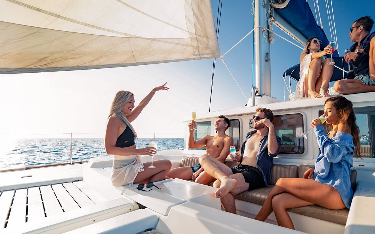 Group enjoying drinks on a catamaran during the Isla Mujeres tour.
